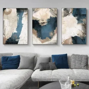 Triptych of abstract navy and beige wooden wall art panels over a gray sofa