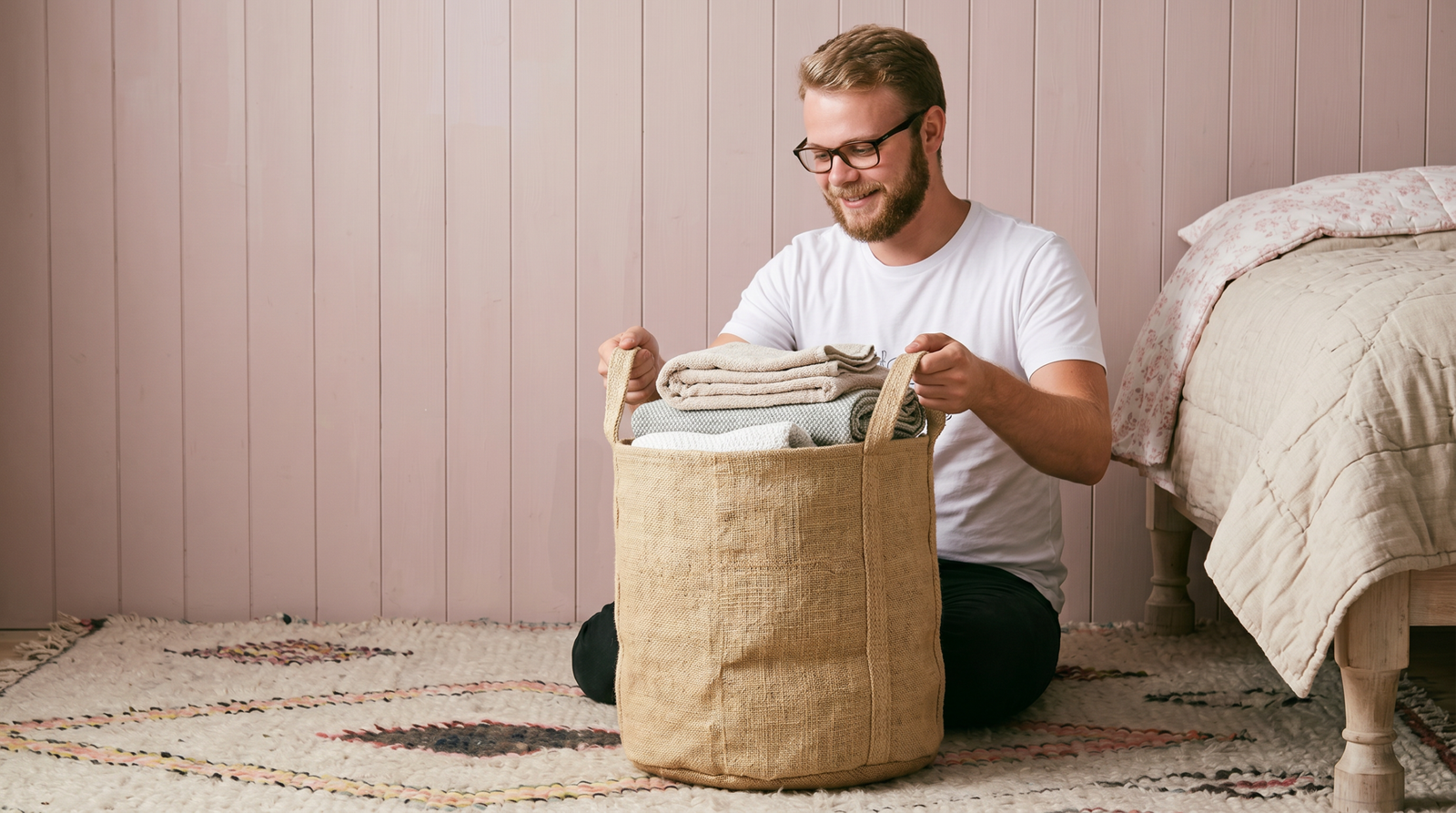 Handwoven jute storage basket filled with folded linens in bedroom
